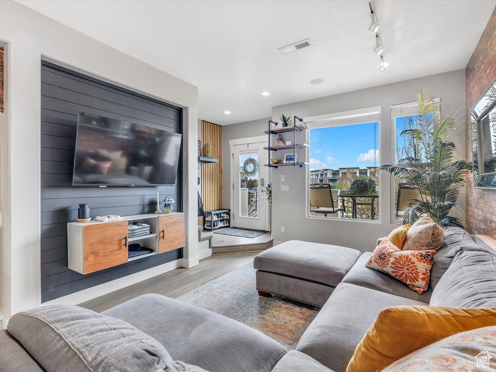 Living room featuring wood finished floors, visible vents, a wealth of natural light, and track lighting