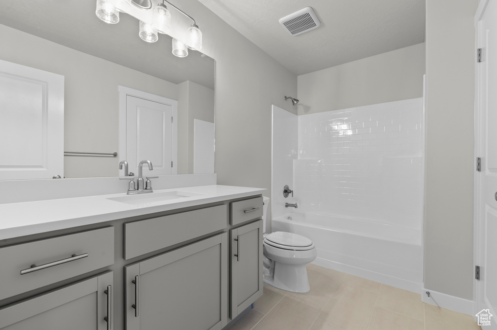 Bathroom with toilet, vanity, shower / washtub combination, and tile patterned flooring