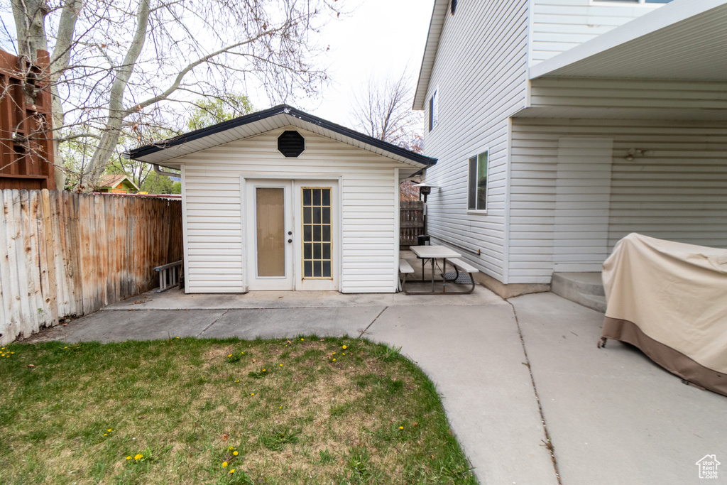Back of house featuring fence, an outbuilding, and a patio area