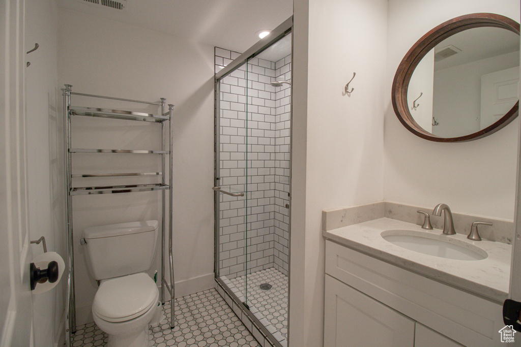 Bathroom with a shower stall, visible vents, toilet, and vanity