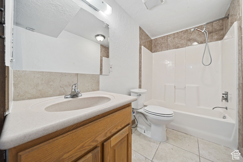 Bathroom with shower / washtub combination, toilet, vanity, and tile patterned floors