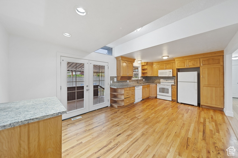 Kitchen featuring recessed lighting, visible vents, a sink, white appliances, and light wood-type flooring
