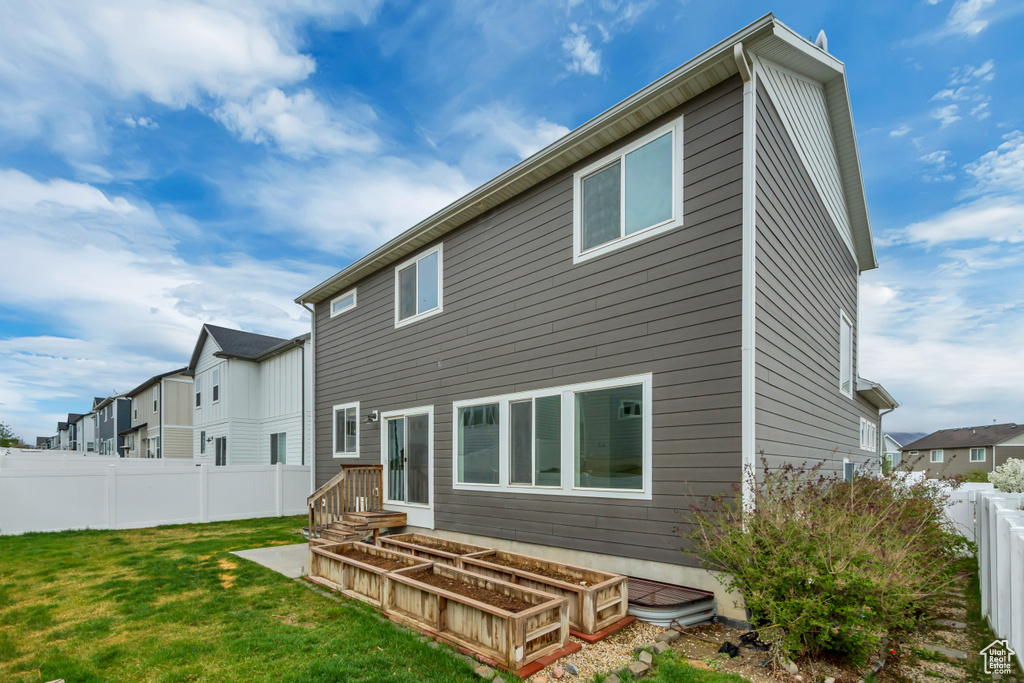 Rear view of property featuring a residential view, a lawn, and a fenced backyard