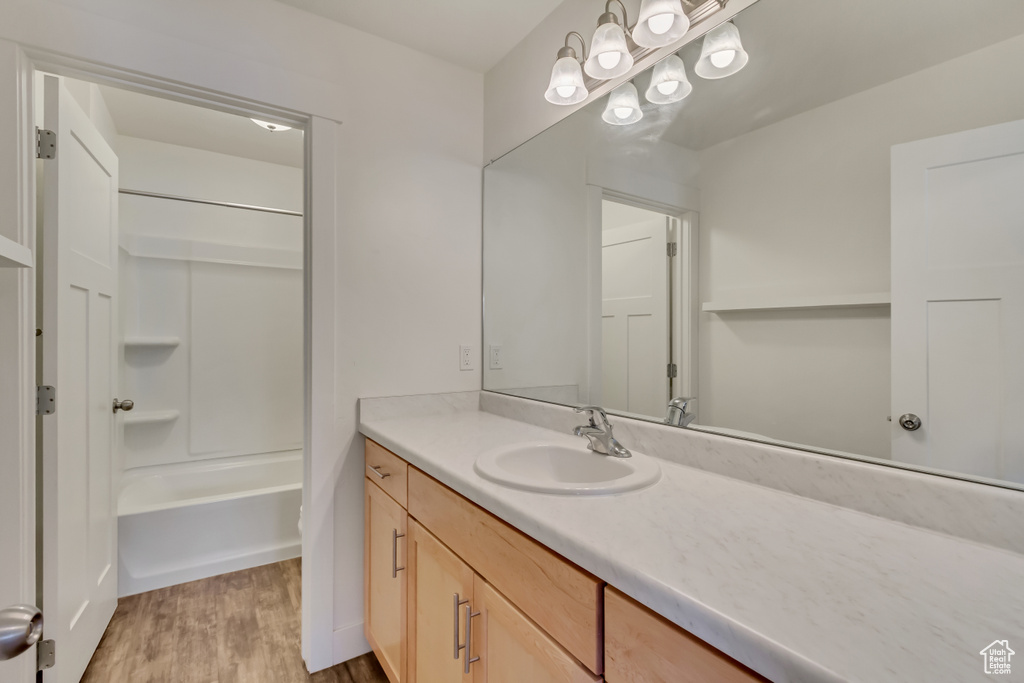 Full bathroom with shower / tub combination, wood finished floors, and vanity