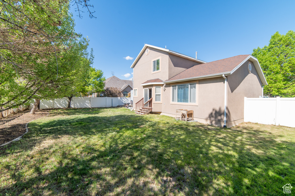 Rear view of house with entry steps and stucco siding