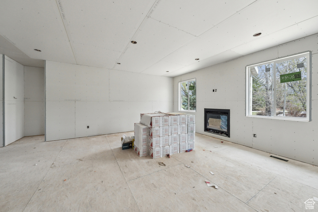Unfurnished living room with a glass covered fireplace and visible vents