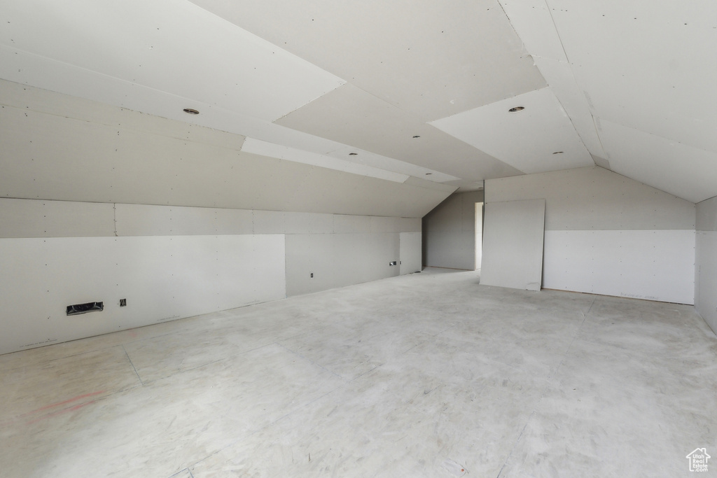 Bonus room featuring concrete floors and vaulted ceiling