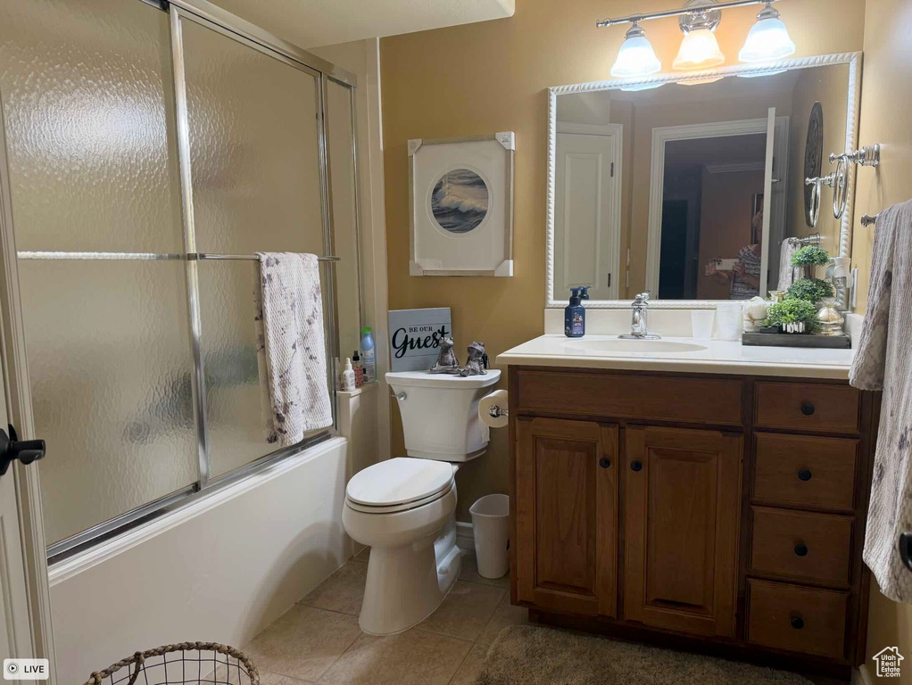 Full bathroom featuring tile patterned flooring, vanity, bath / shower combo with glass door, and toilet