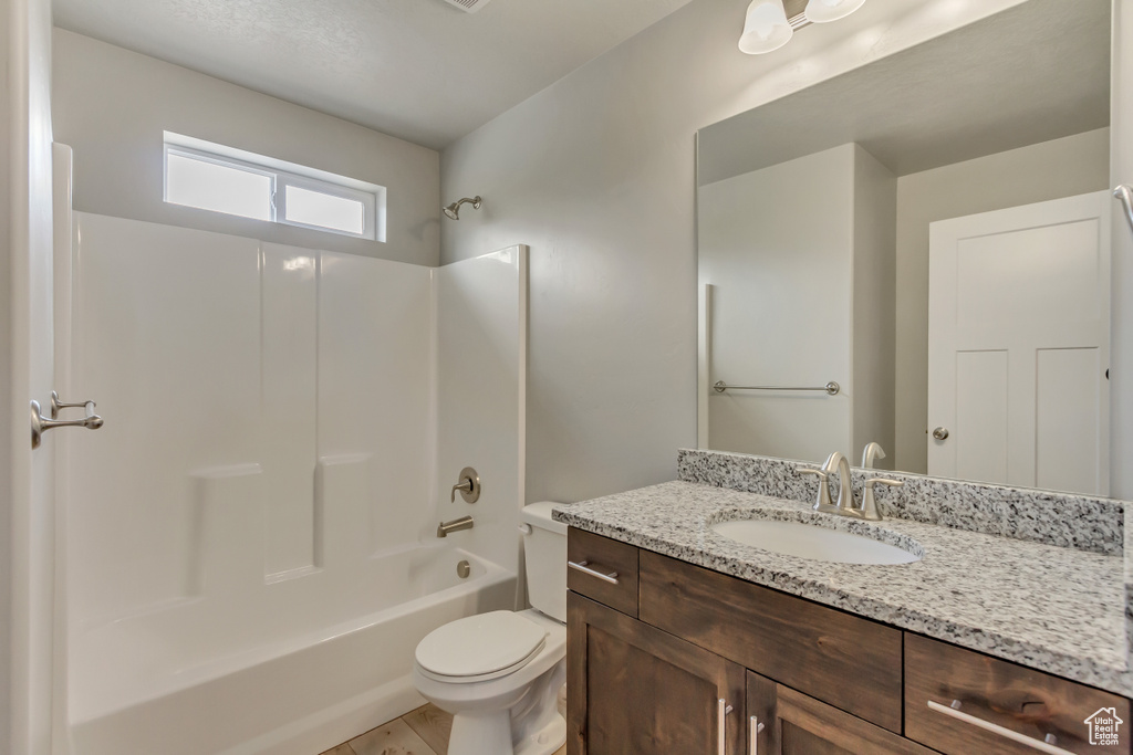 Bathroom with toilet, vanity, and bathtub / shower combination