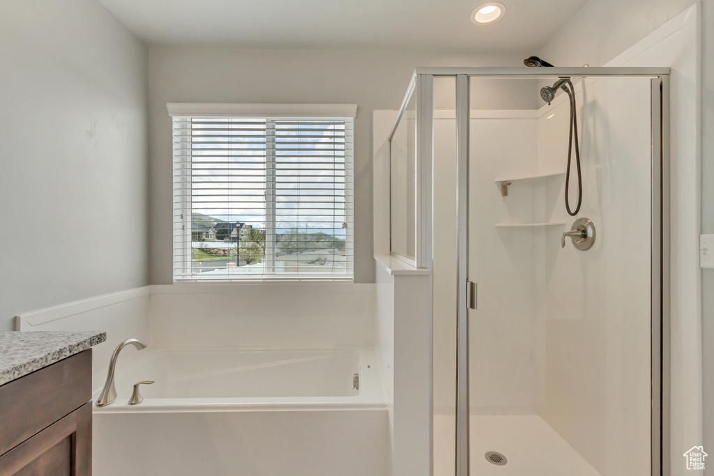 Full bath with a garden tub, vanity, recessed lighting, and a shower stall