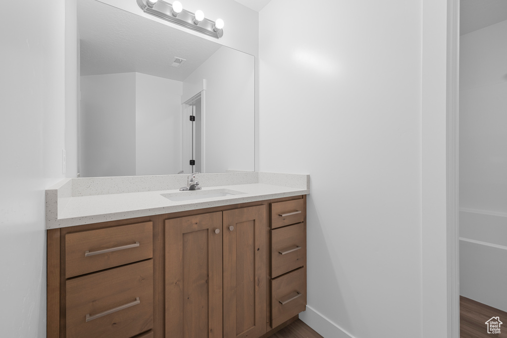 Bathroom featuring vanity and wood finished floors