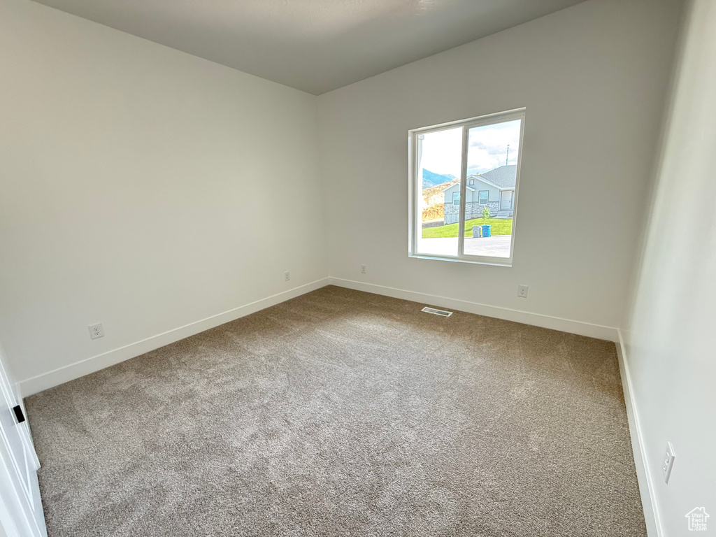 Spare room with baseboards and carpet
