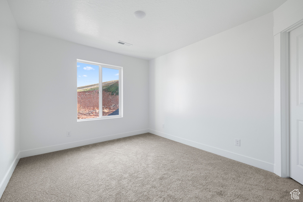 Carpeted spare room with baseboards