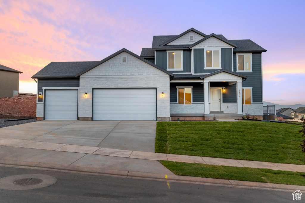 View of front of house with a garage, concrete driveway, a lawn, a porch, and a shingled roof