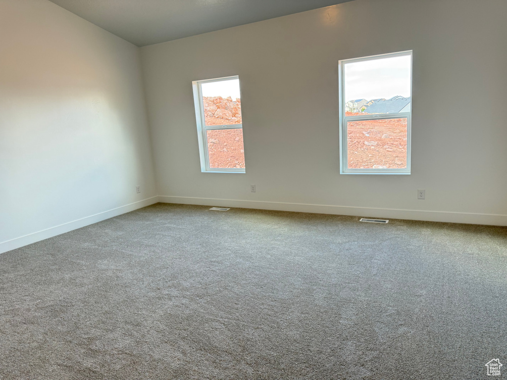 Spare room with baseboards and carpet