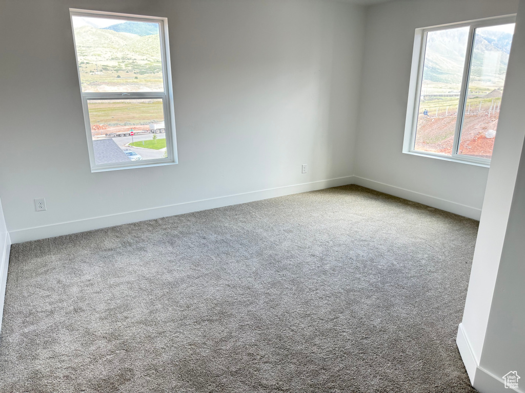 Spare room featuring carpet floors and baseboards