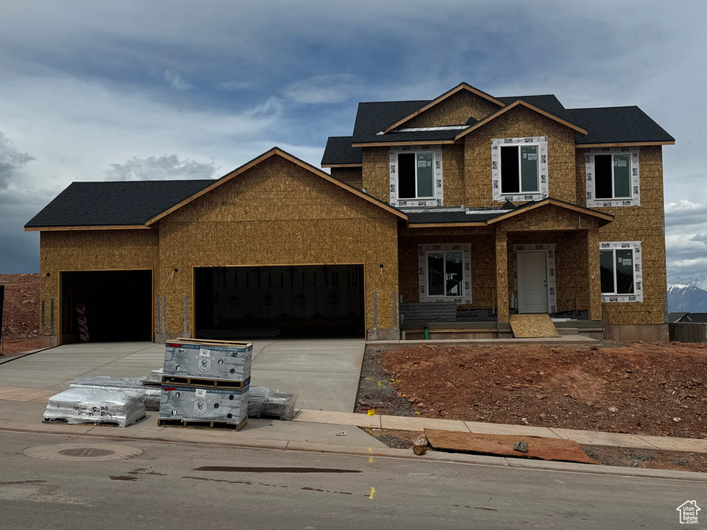 View of front of home featuring an attached garage, driveway, and brick siding