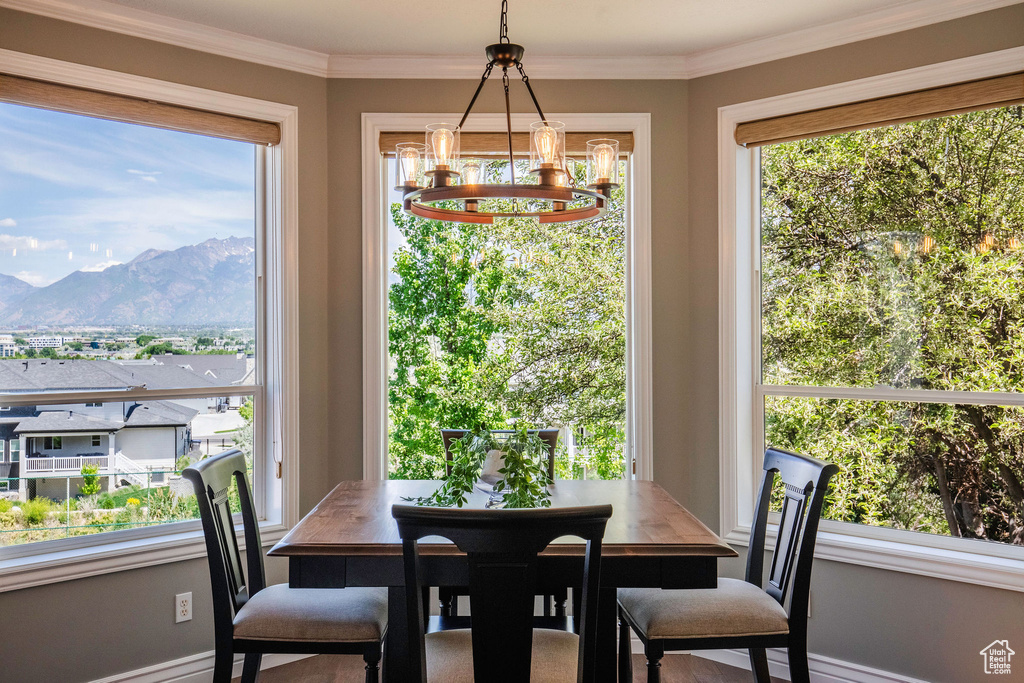 Dining space with a chandelier, a mountain view, and ornamental molding