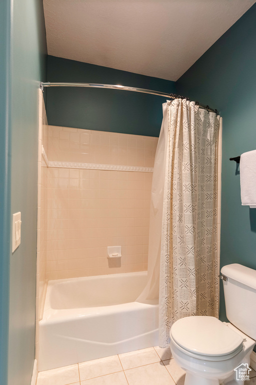 Full bath featuring shower / bathtub combination with curtain and tile patterned flooring