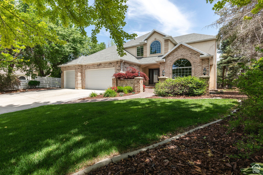 Traditional-style house with concrete driveway, an attached garage, roof with shingles, and stucco siding