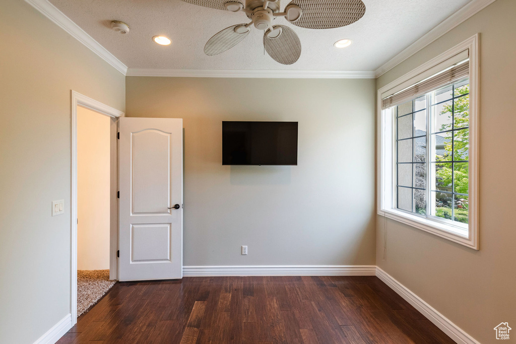 Unfurnished bedroom featuring dark wood-type flooring, ornamental molding, recessed lighting, and ceiling fan