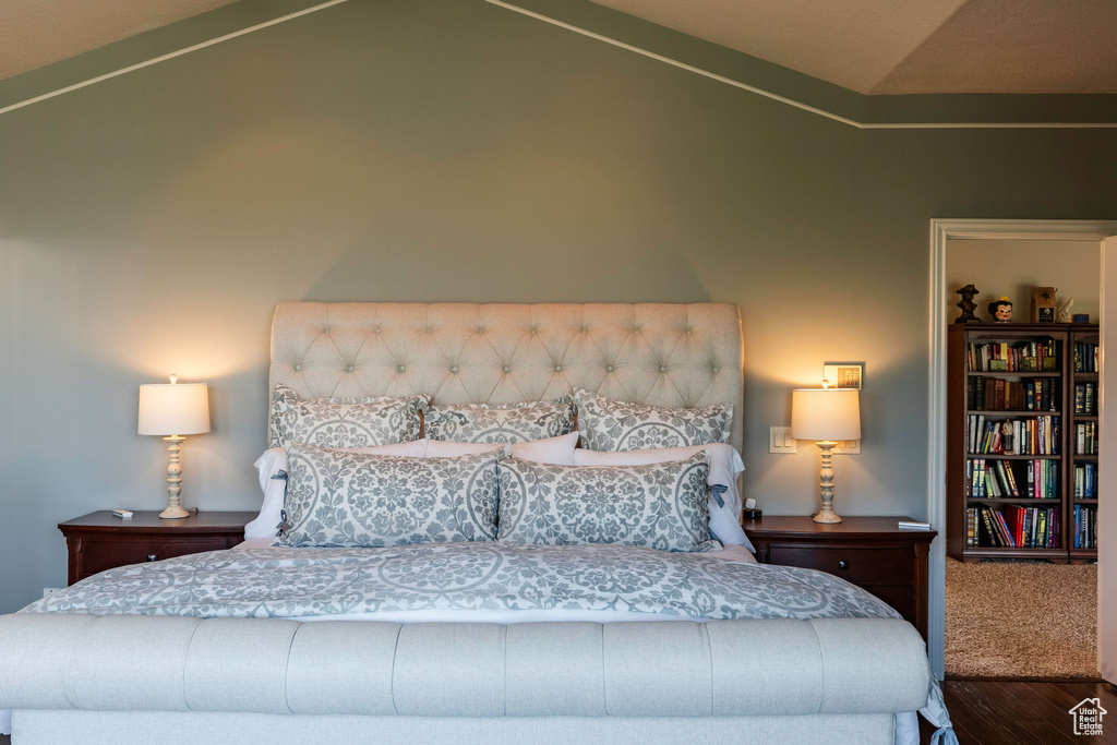 Bedroom with vaulted ceiling and wood finished floors