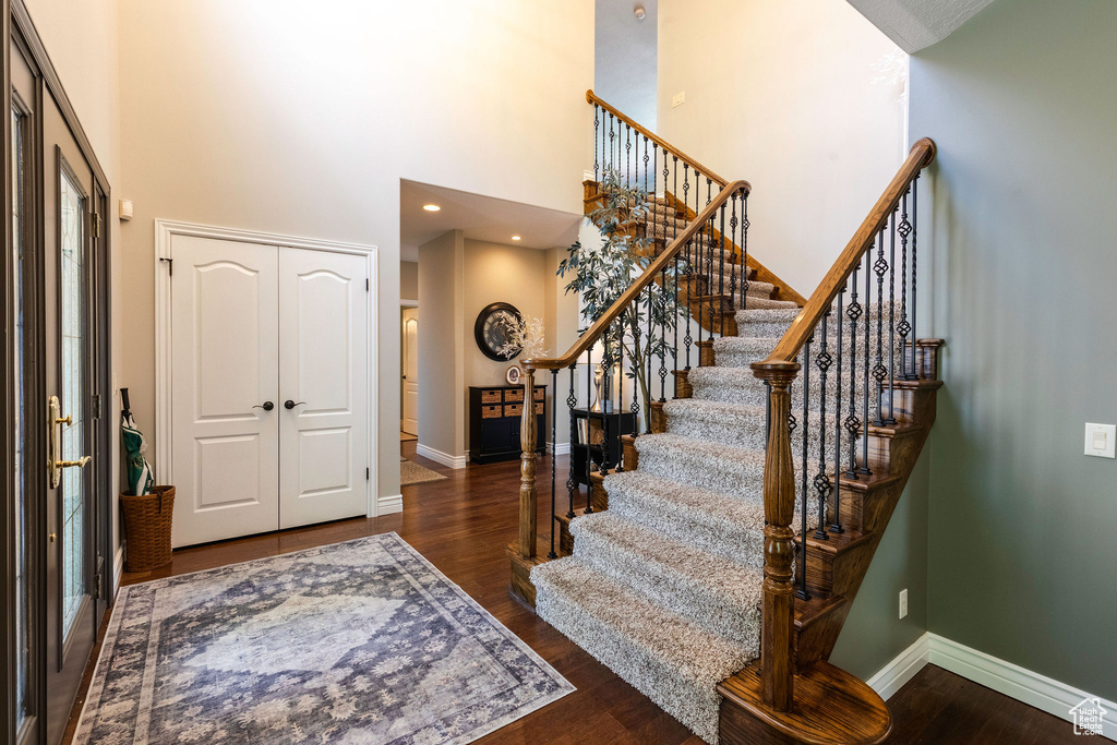 Entrance foyer featuring a towering ceiling, wood finished floors, and stairs