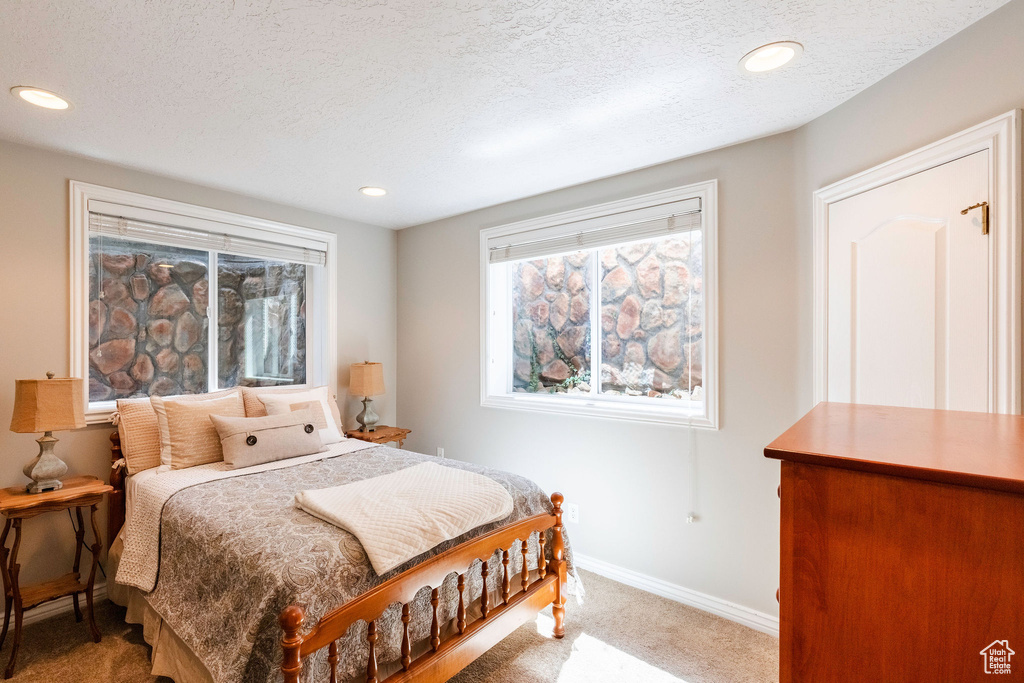Bedroom with carpet, a textured ceiling, and recessed lighting