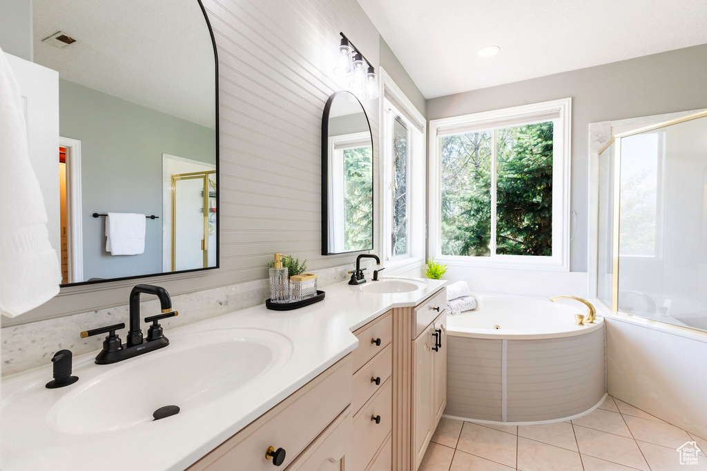Bathroom with a jetted tub, double vanity, a shower stall, and tile patterned floors