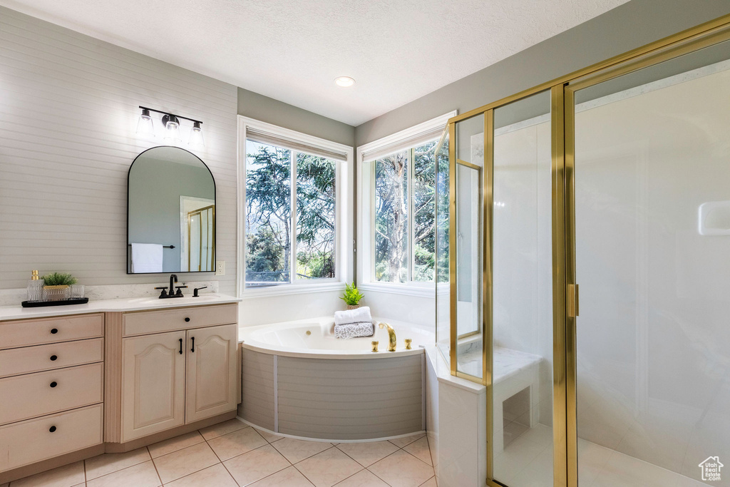 Bathroom featuring vanity, a shower stall, a garden tub, tile patterned flooring, and recessed lighting