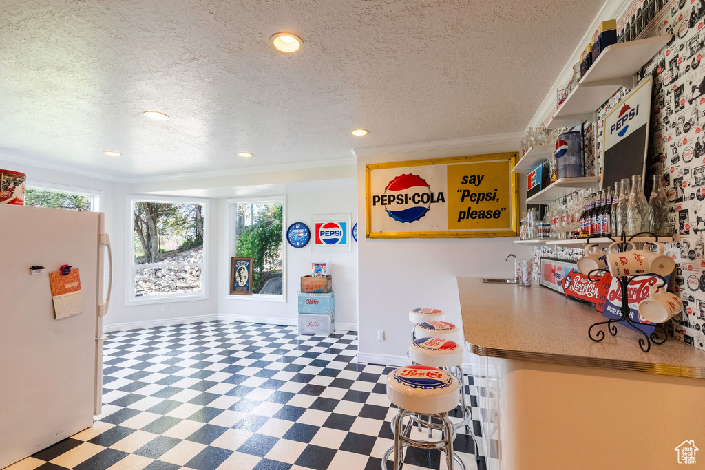 Game room featuring tile patterned floors, a textured ceiling, crown molding, and recessed lighting