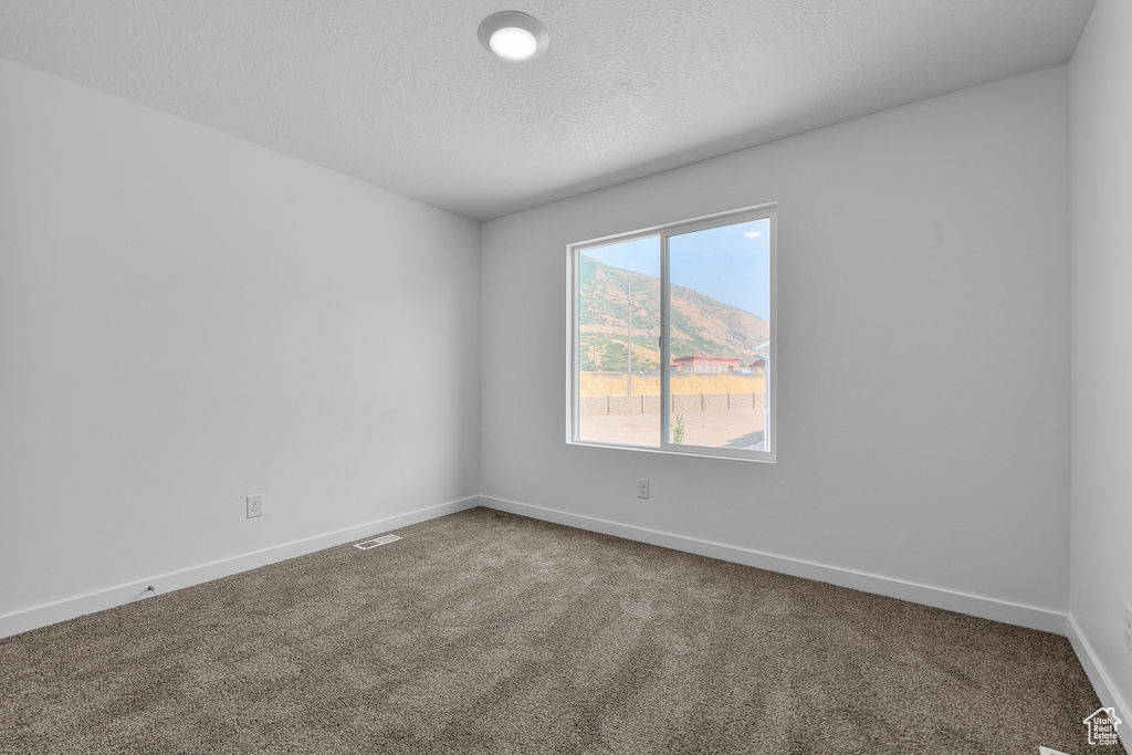 Carpeted spare room with baseboards and visible vents