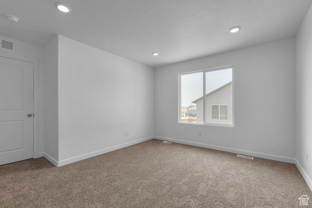 Unfurnished room featuring baseboards, visible vents, carpet, and recessed lighting
