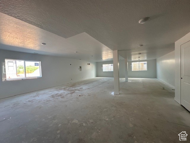 Below grade area with a textured ceiling and healthy amount of natural light