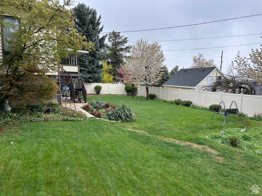 View of yard featuring stairs and a fenced backyard