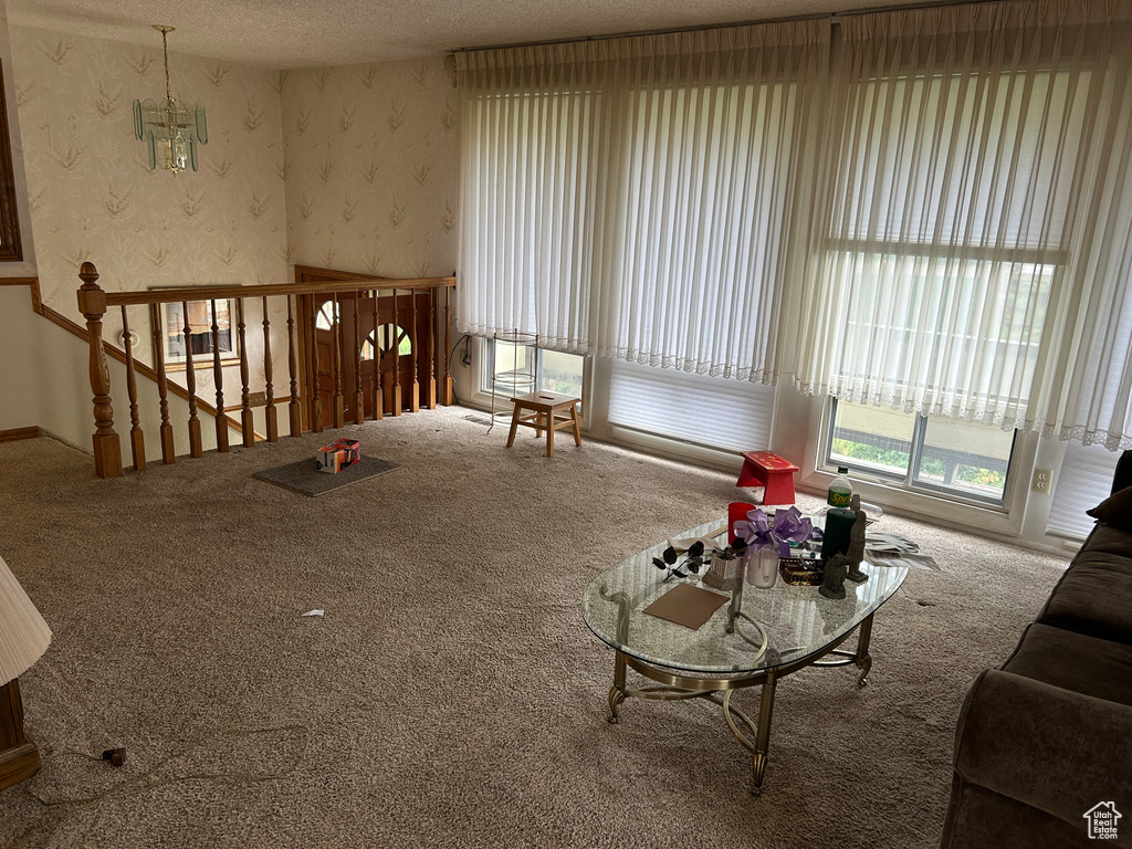Carpeted living area with a textured ceiling and wallpapered walls
