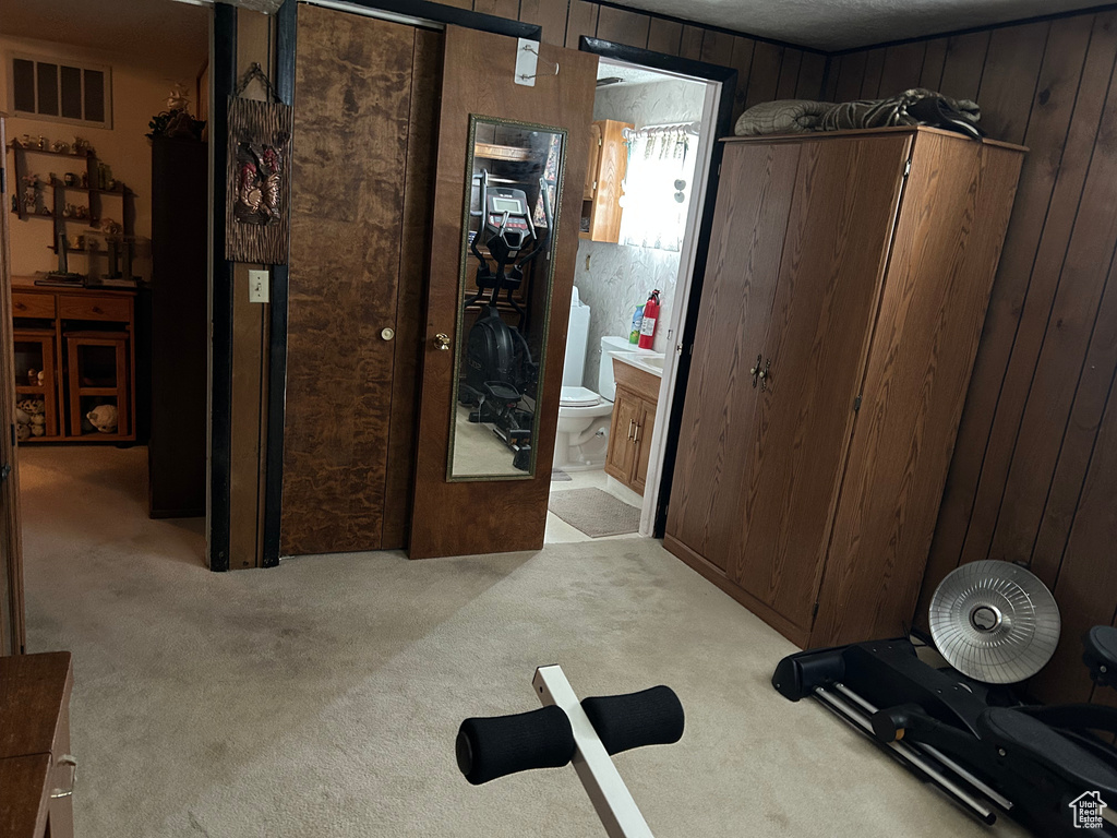 Workout room with light carpet, wooden walls, and visible vents
