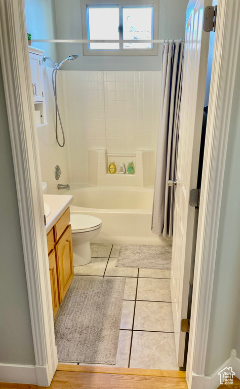 Bathroom with vanity, tile patterned floors, shower / tub combo, and toilet