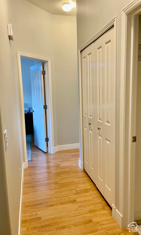 Hallway featuring light wood-type flooring and baseboards