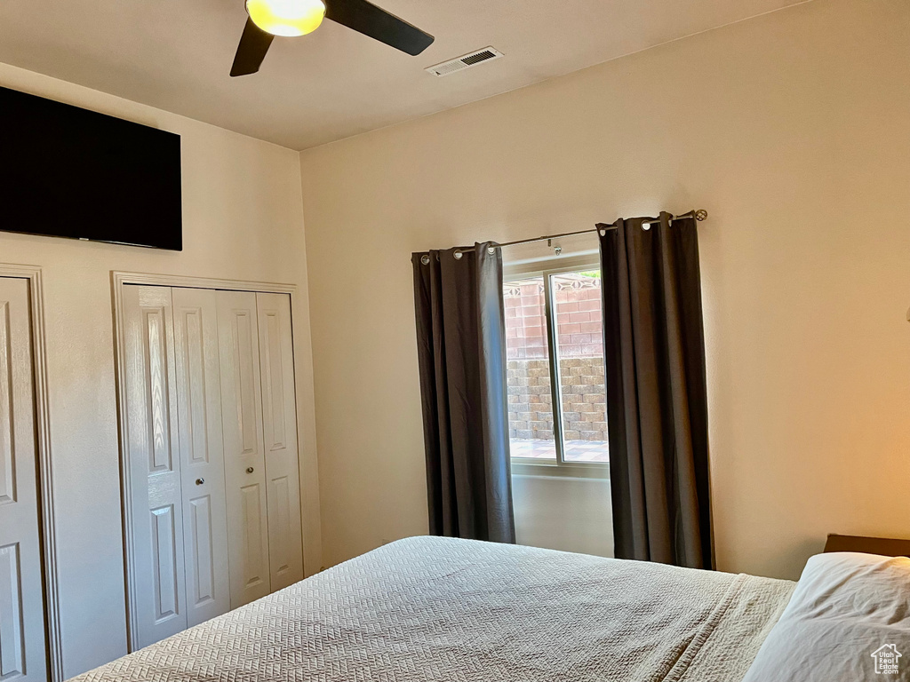 Bedroom featuring a ceiling fan and two closets