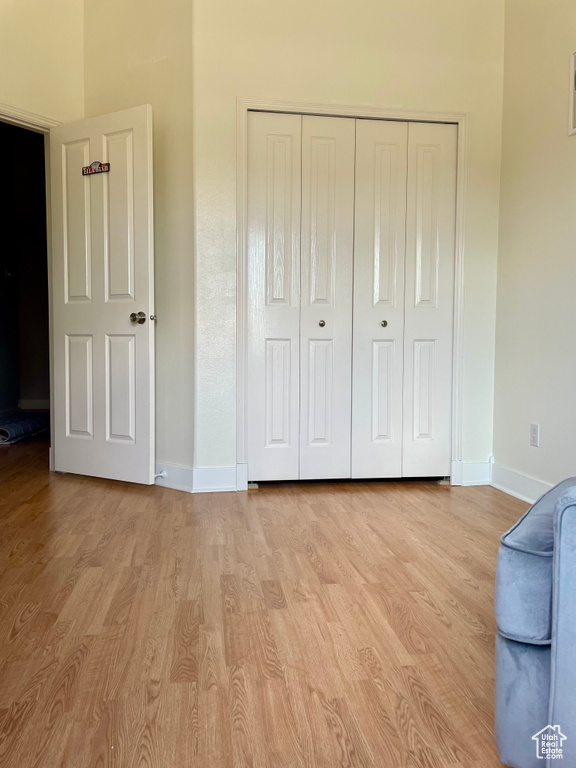 Unfurnished bedroom with baseboards, wood finished floors, and a closet