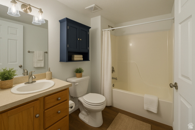 Full bath with vanity, wood finished floors, and shower / tub combo