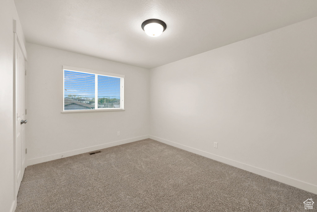 Spare room with baseboards, carpet flooring, and visible vents