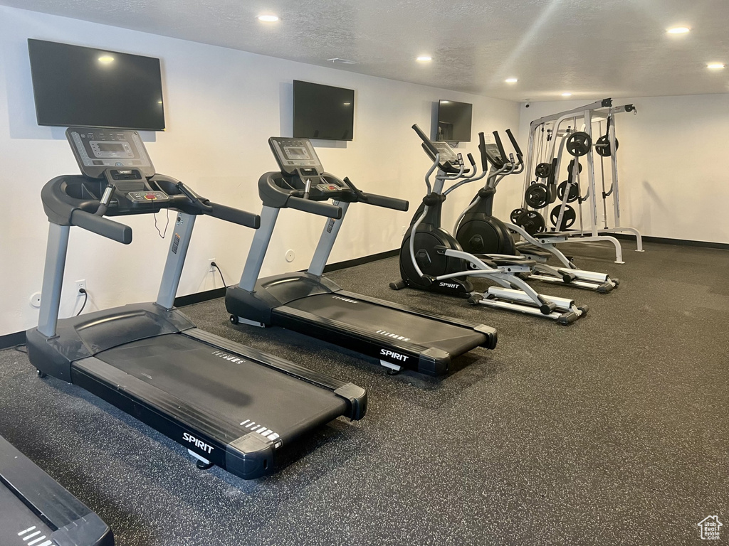 Exercise room with baseboards and recessed lighting