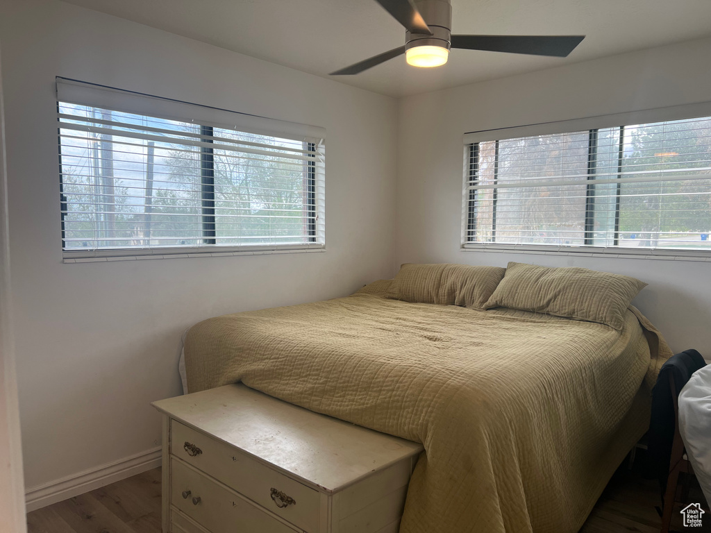 Bedroom with ceiling fan, baseboards, and wood finished floors