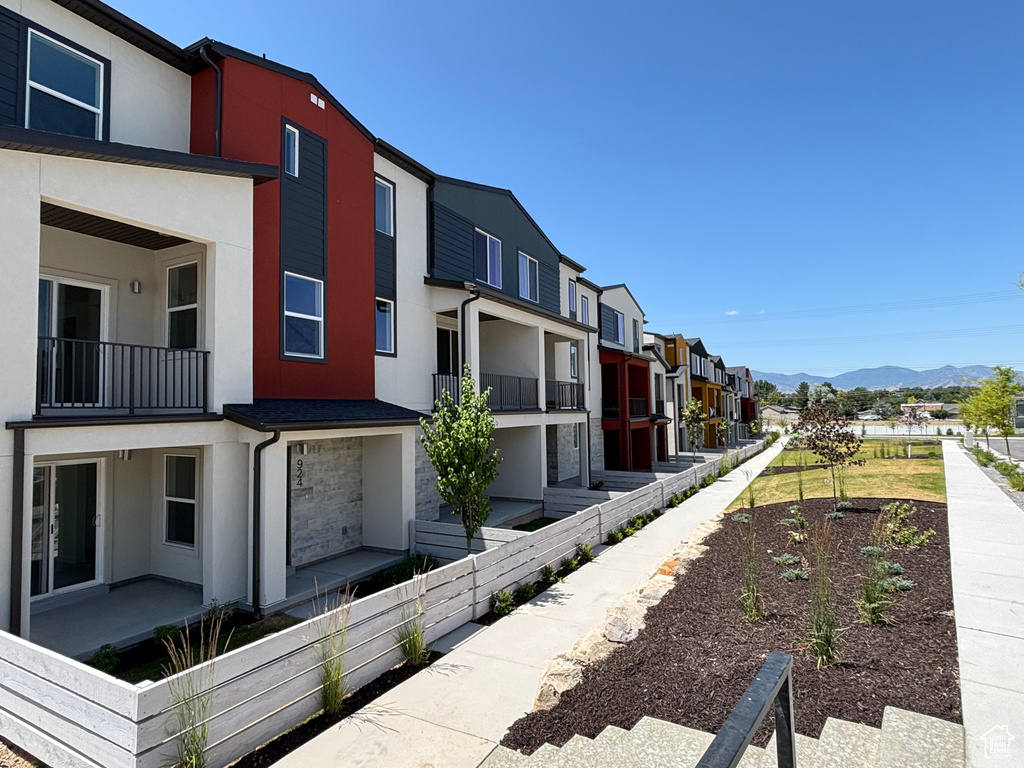 View of property exterior featuring stucco siding, a mountain view, and a residential view