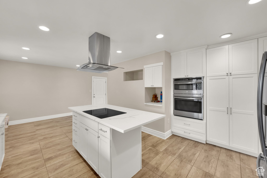 Kitchen with black appliances, island exhaust hood, white cabinetry, a kitchen island, and recessed lighting