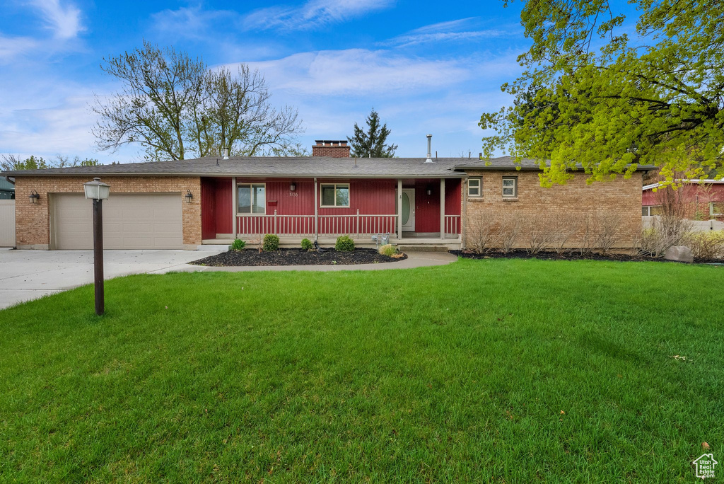Ranch-style house with concrete driveway, a chimney, covered porch, an attached garage, and a front yard