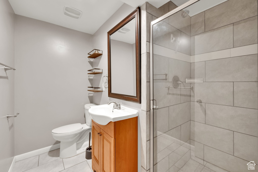 Bathroom with a shower stall, tile patterned floors, vanity, toilet, and visible vents