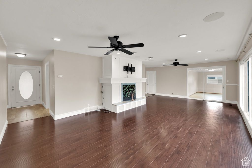 Unfurnished living room with ceiling fan, baseboards, wood finished floors, and recessed lighting